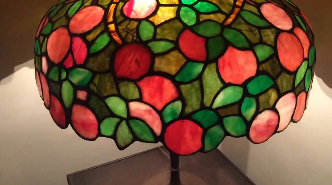 Lampada da tavolo antica in stile Art Deco con design floreale colorato sulla lampada.