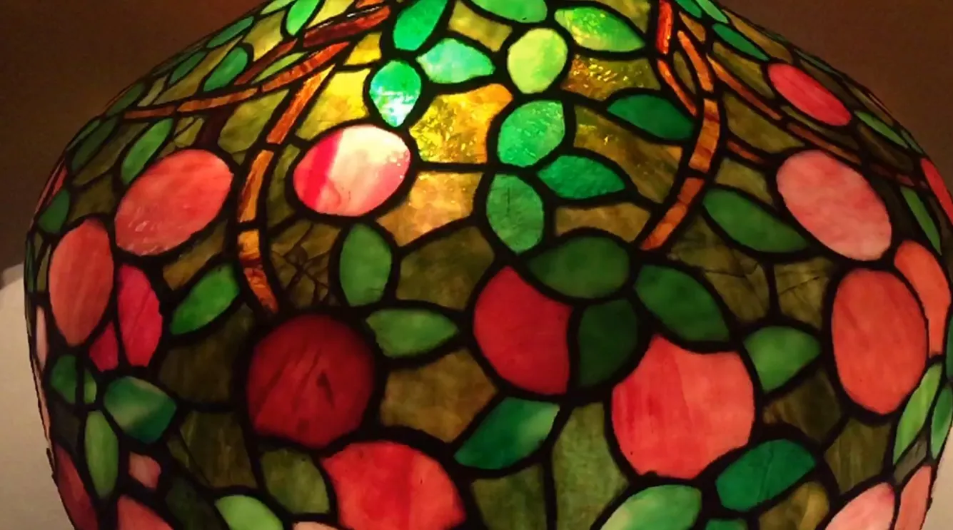 Antique table lamp Art Deco with green and pink leaf design, enhances a cozy atmosphere.