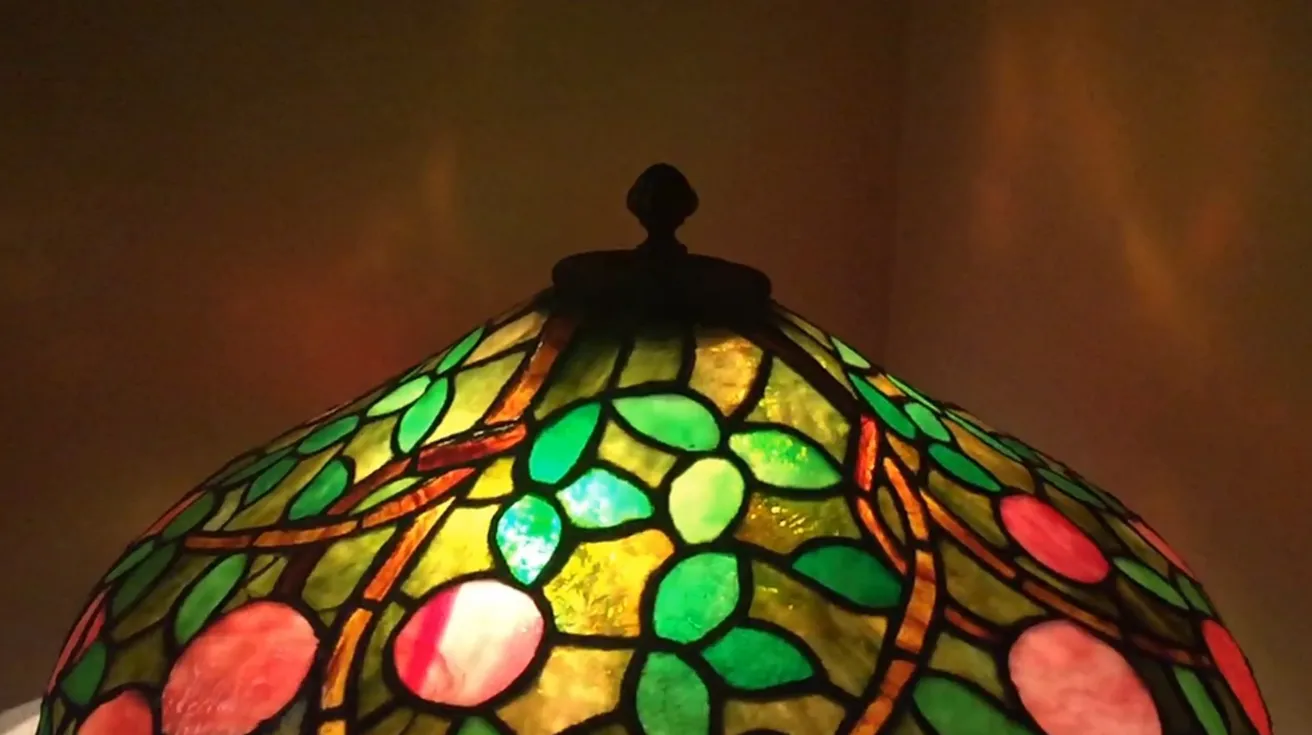 Lampada da tavolo antica con design Art Deco, dettagli colorati.