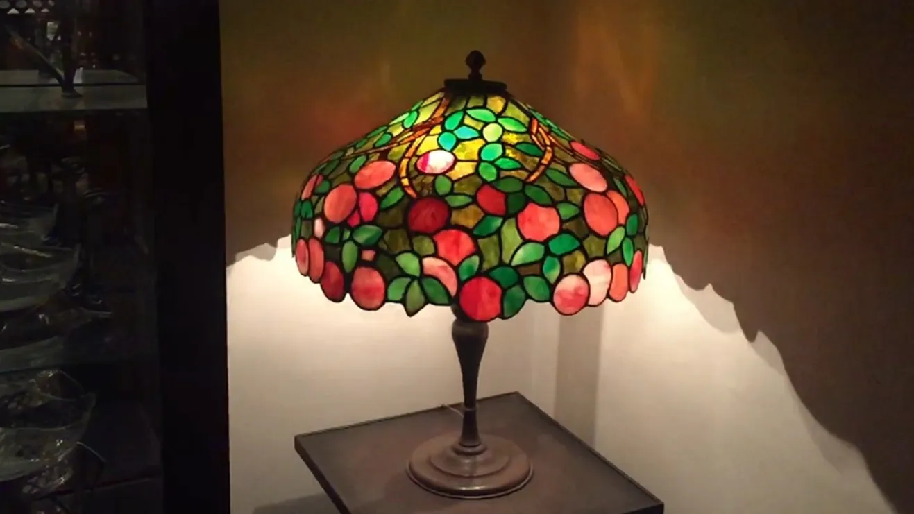 Luminária de mesa antiga Art Deco com tons verdes e rosas.