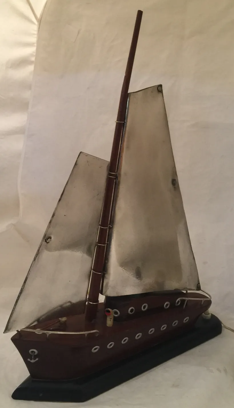 Antique table lamp shaped like a boat with metallic sails.