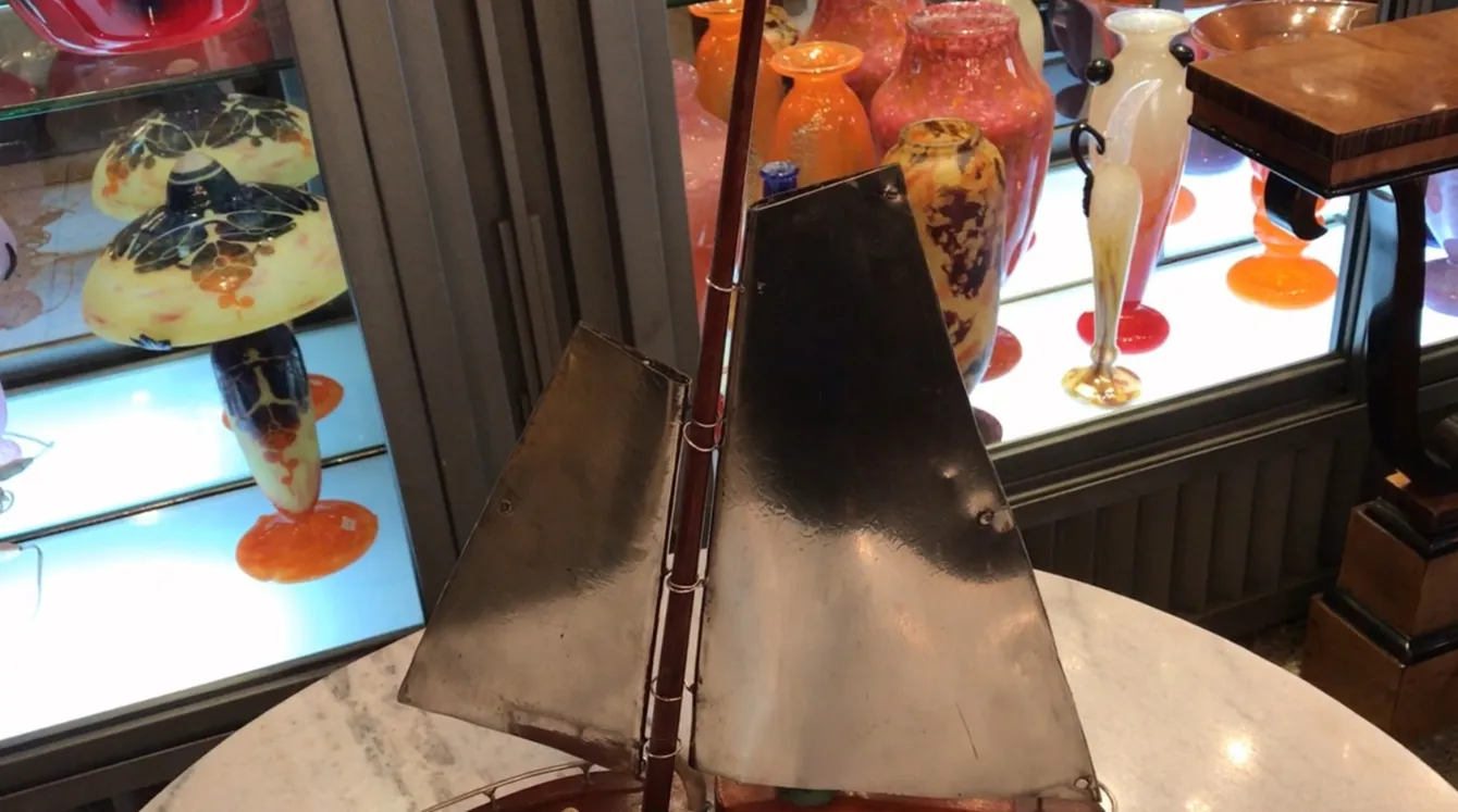 lampada da tavolo antica in stile art deco con base in metallo e paralume riflettente, circondata da vasi colorati