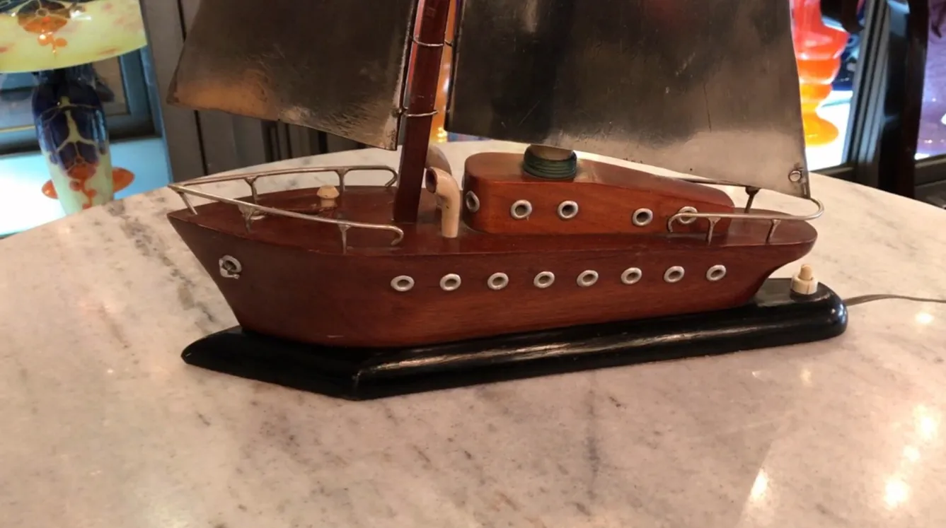 Lampe de bureau ancienne en forme de bateau, éclairant un espace accueillant.