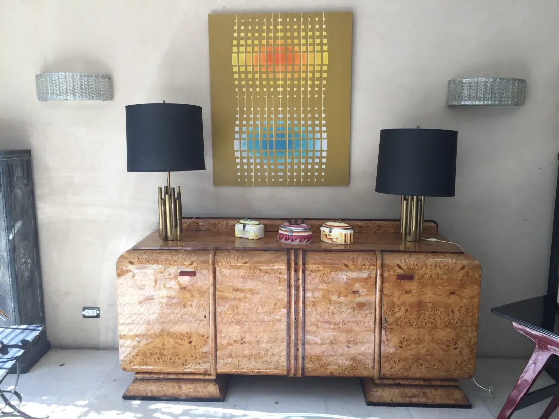 Lampe de bureau antique Art Deco avec base dorée et abat-jour noir dans un cadre moderne élégant.