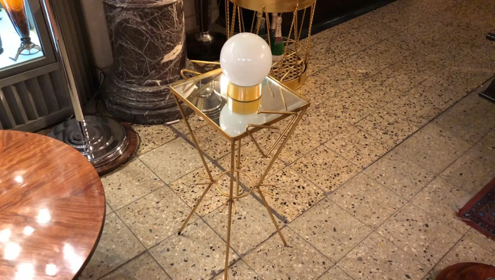 lampe de bureau antique avec base dorée et lumière sphérique, dans une pièce avec des meubles et une décoration classiques