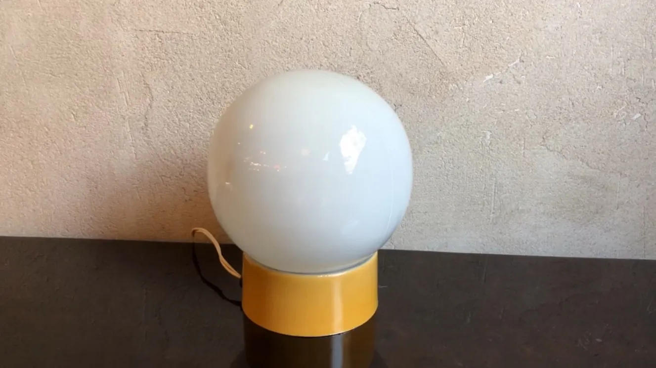 Lampada da tavolo antica sferica con base colorata in un ambiente accogliente
