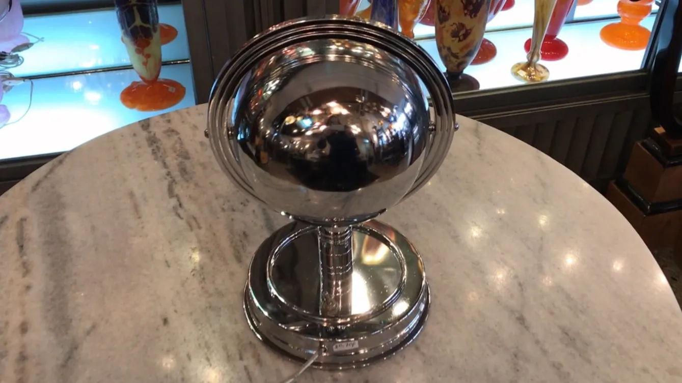 Lampada da tavolo antica Art Deco con base rotonda e globi riflettenti, circondata da oggetti decorativi.