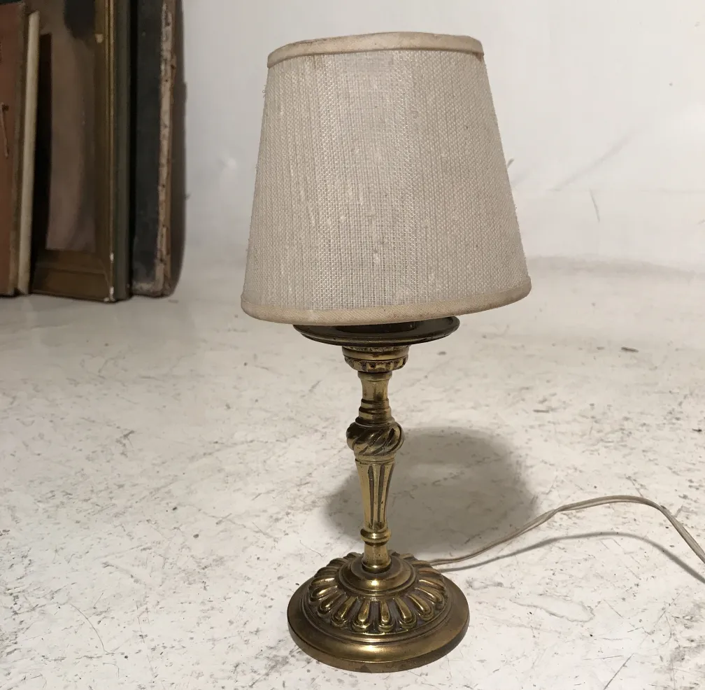 antica lampada da tavolo art deco con base decorativa e paralume chiaro, in un contesto di antiquariato
