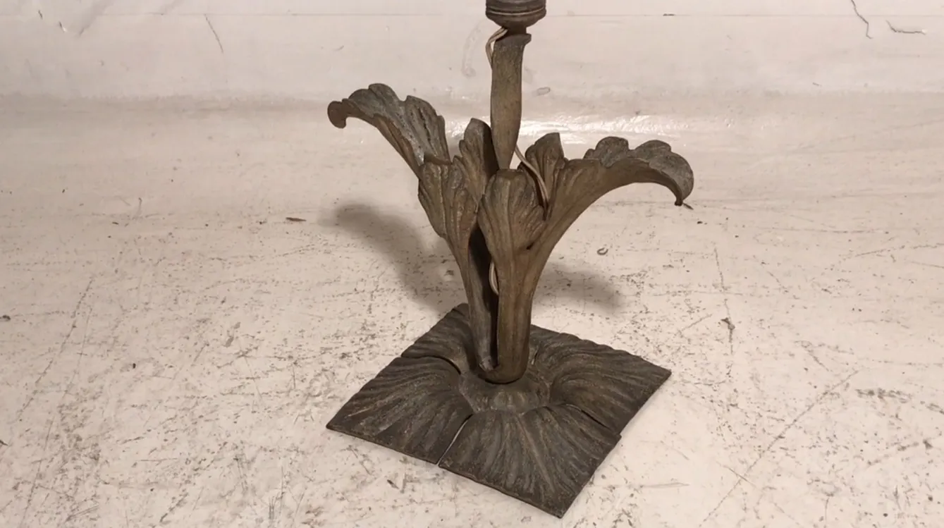 Antique Art Deco table lamp with decorative base in a minimalist setting.