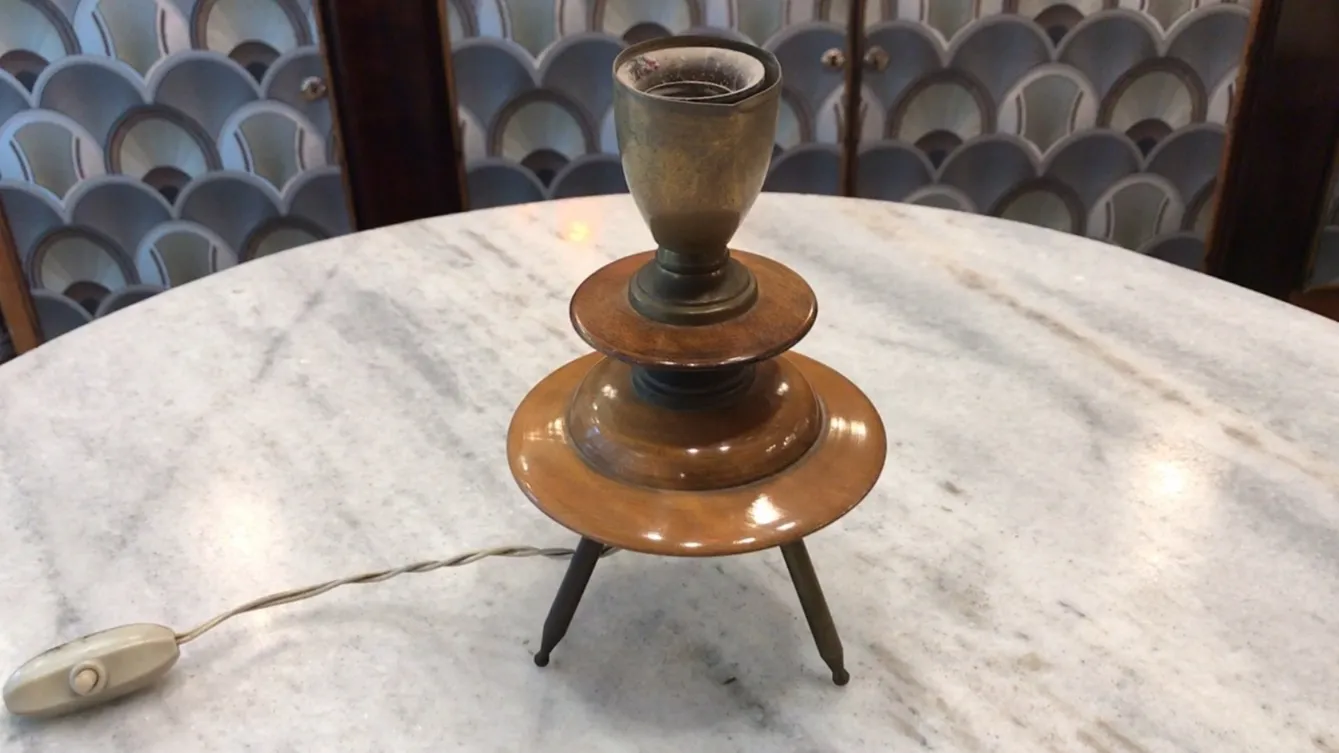 Antigua lámpara de mesa con diseño Art Deco en bronce, sobre una mesa de mármol.