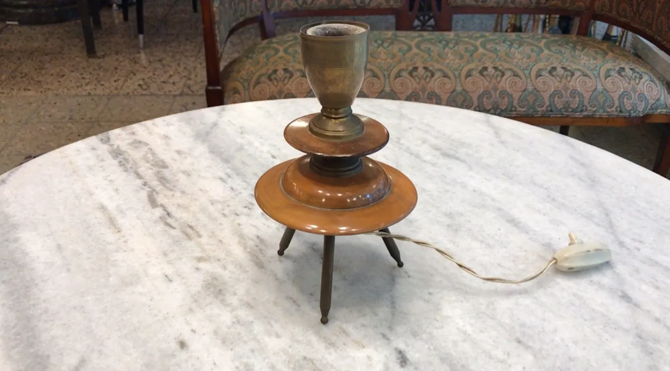 Lampada da tavolo antica in stile Art Deco con base elegante e dettagli decorativi, posizionata su un tavolo di marmo.