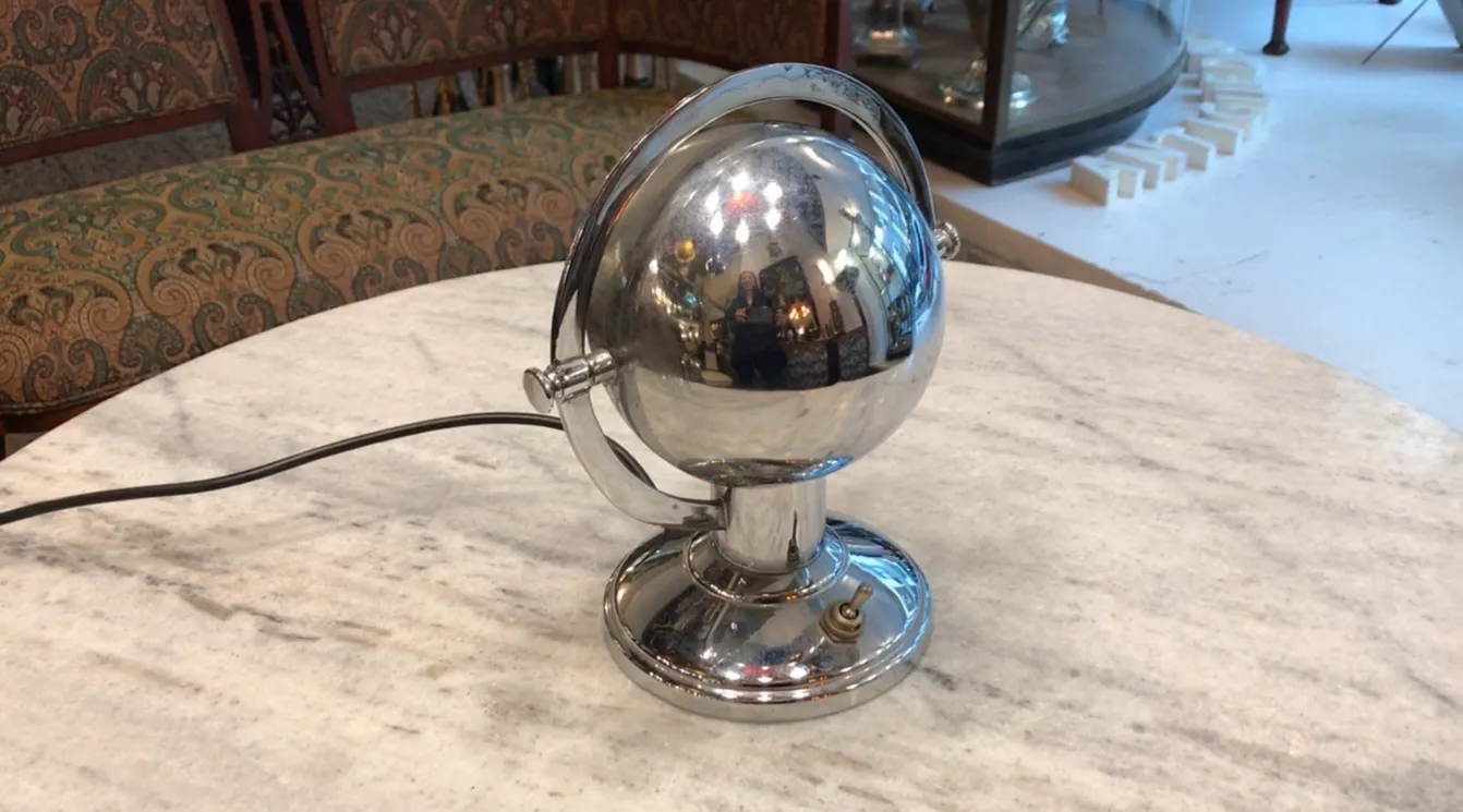 Lampada da tavolo antica con base rotonda e globe lucido, stile Art Deco, in un ambiente classico.