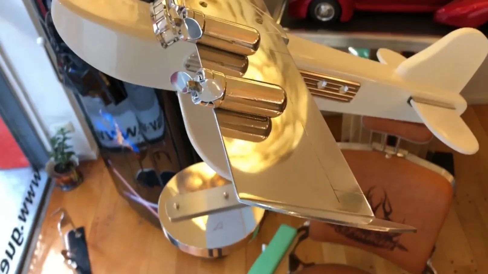 Antikes dekoratives Flugzeug mit metallischen Details vor einem Shop-Hintergrund.