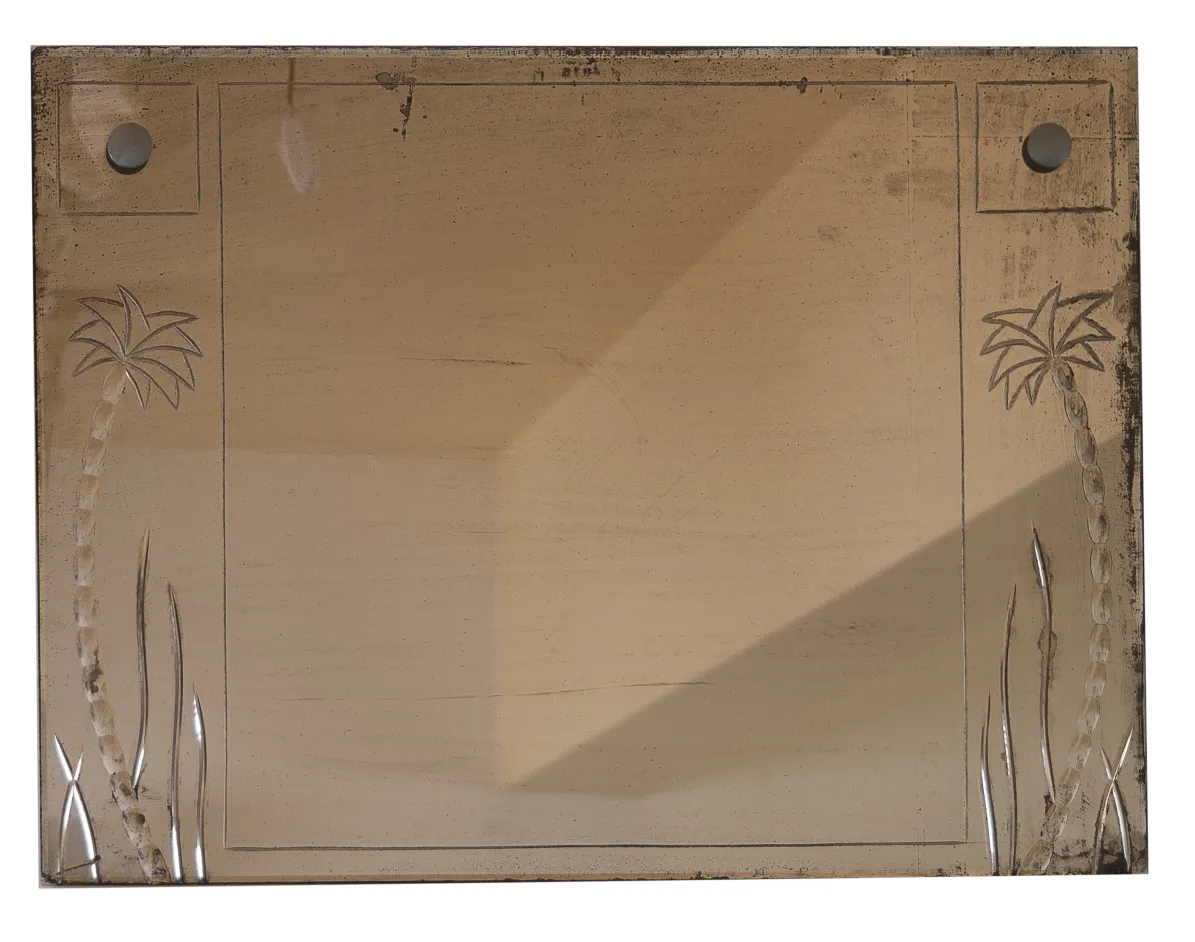 antique mirror featuring palm tree engravings on the edge