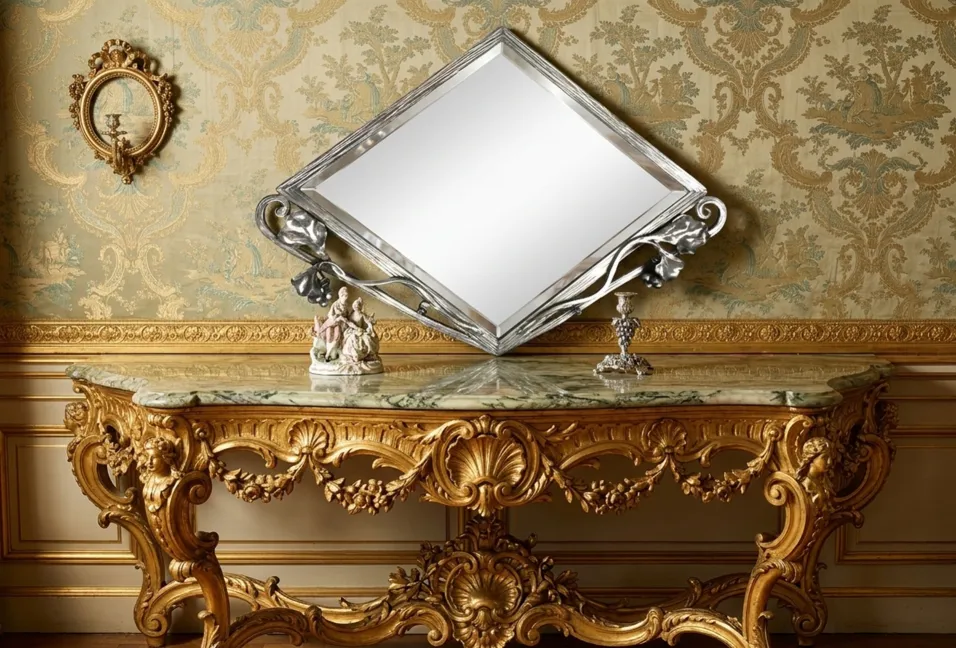 specchio antico con design decorativo in oro e stile art nouveau, contro un muro ornato