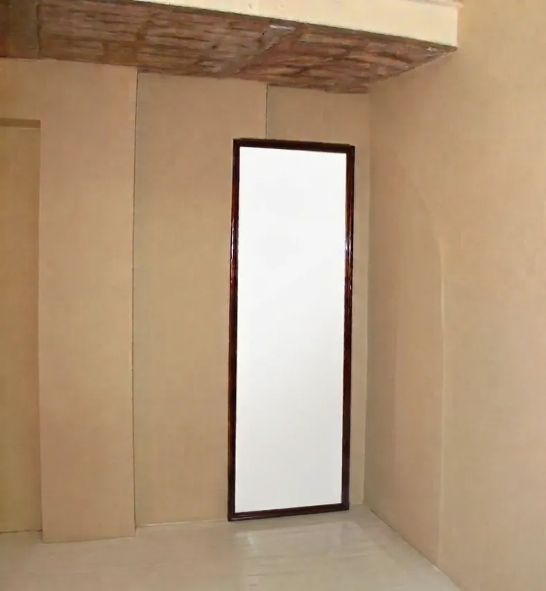 specchio antico da parete con cornice scura in stanza