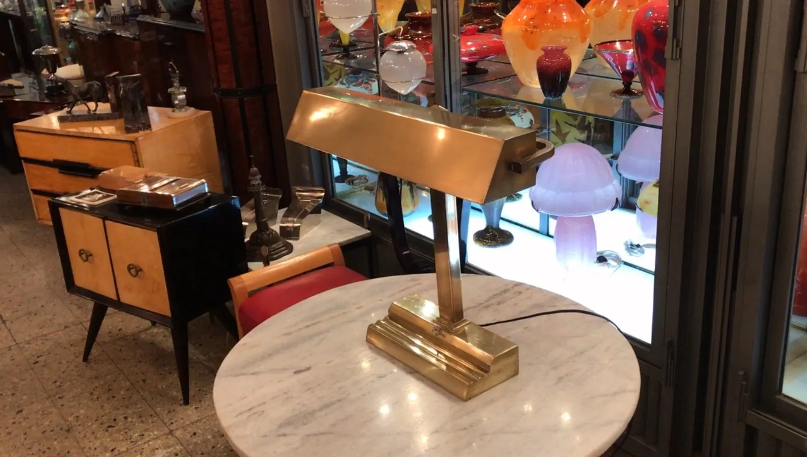 Antique table lamp in Art Deco style on marble table.