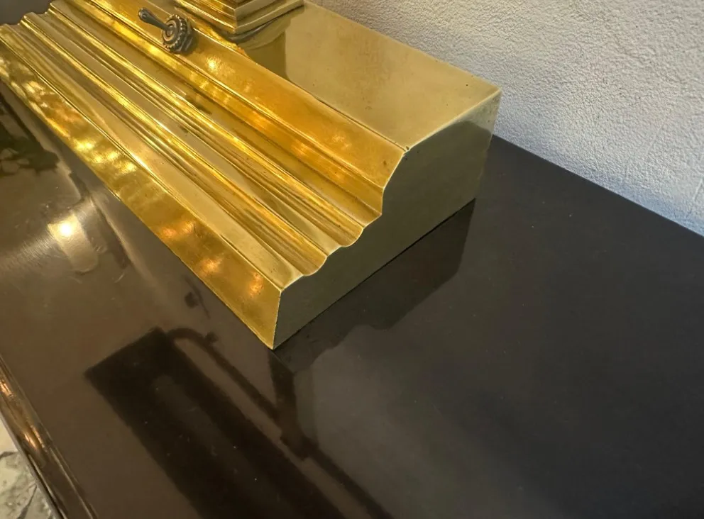 Antike Tischlampe im Art Deco-Stil mit hellem goldenen Sockel, stilisierter Form und Oberflächendetails.