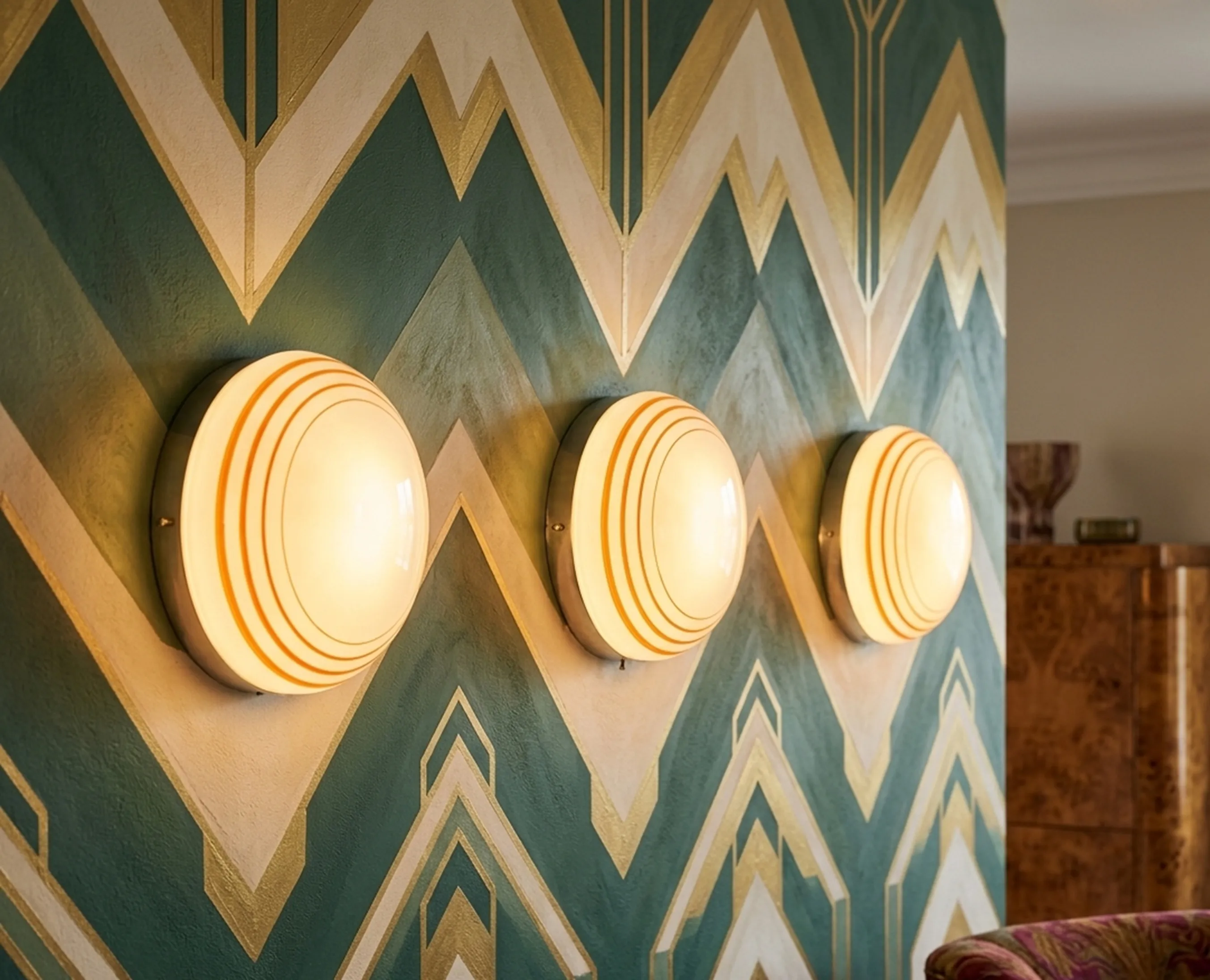 Tre plafoniere antiche con design arrotondato che illuminano il muro