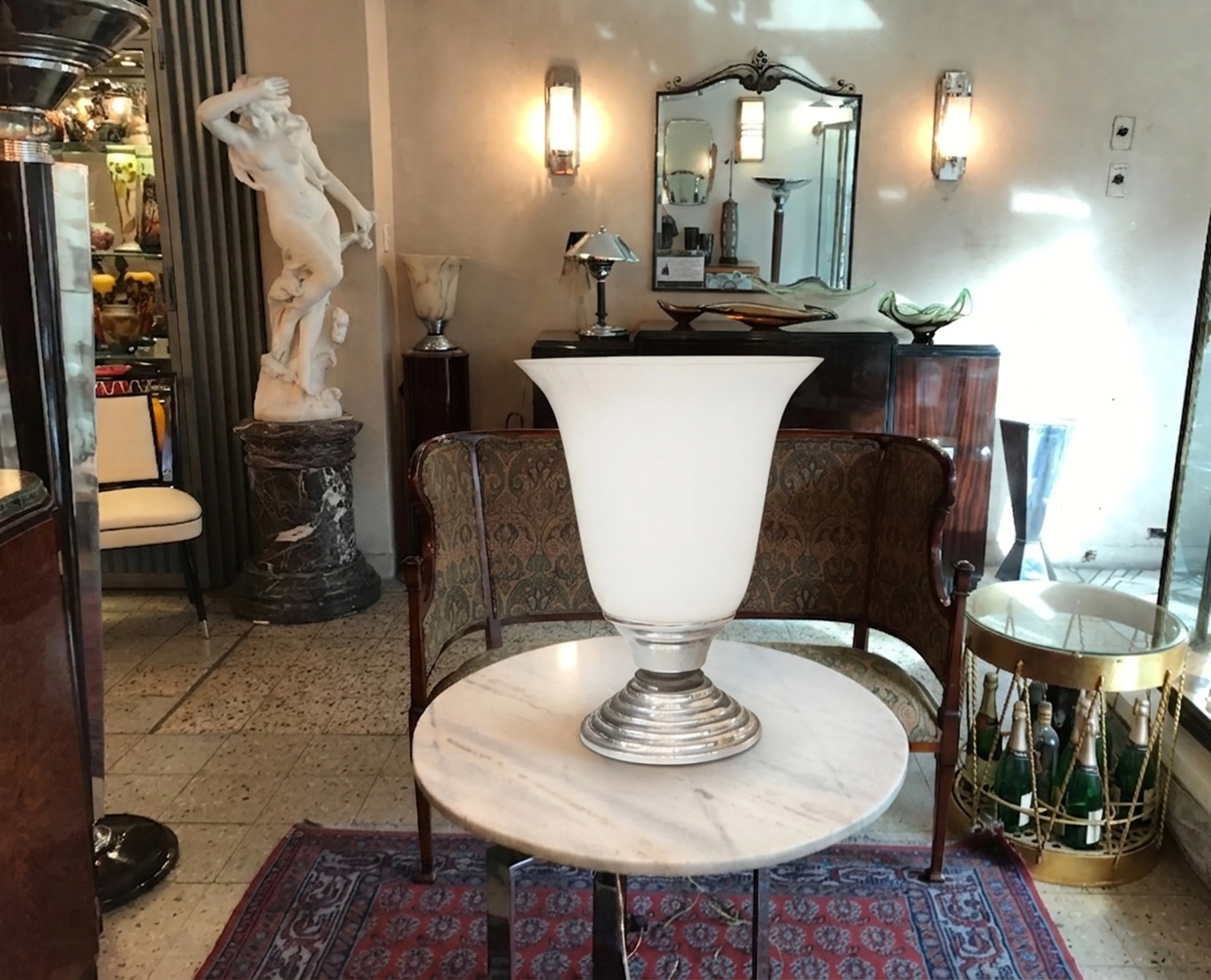 Antique table lamp with white shade and decorative base in elegant room.