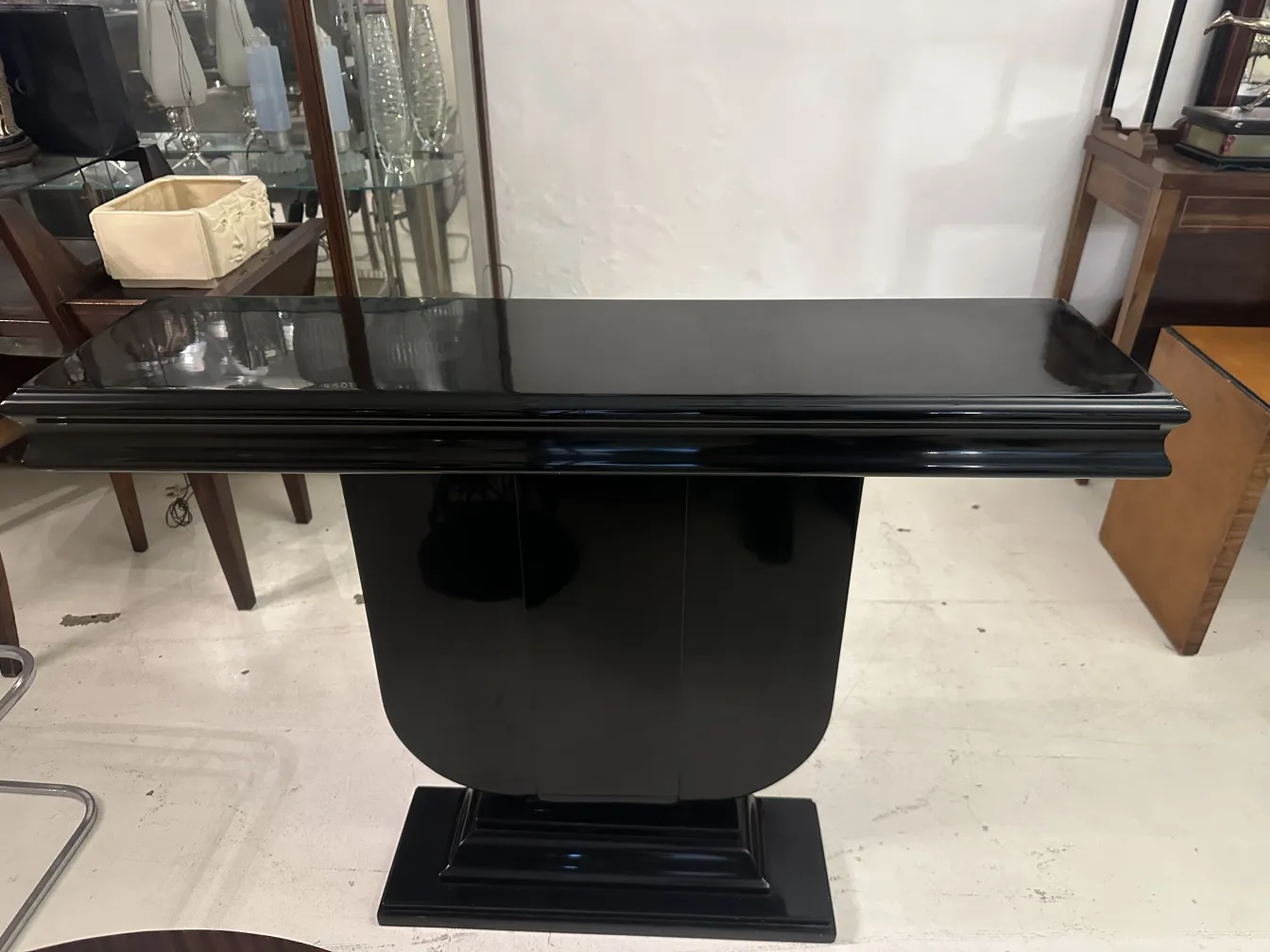 deux élégantes tables de console noires art deco dans un cadre lumineux