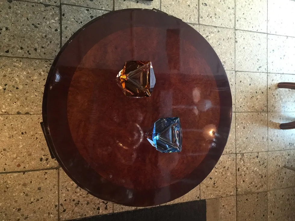 Tavolino da caffè antico con decorazioni vivaci e oggetti intorno.