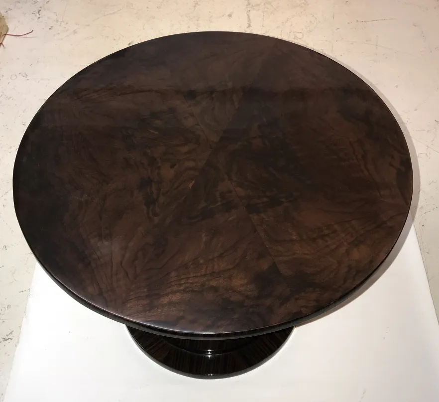 Deux petites tables anciennes avec un dessus rond et sombre.
