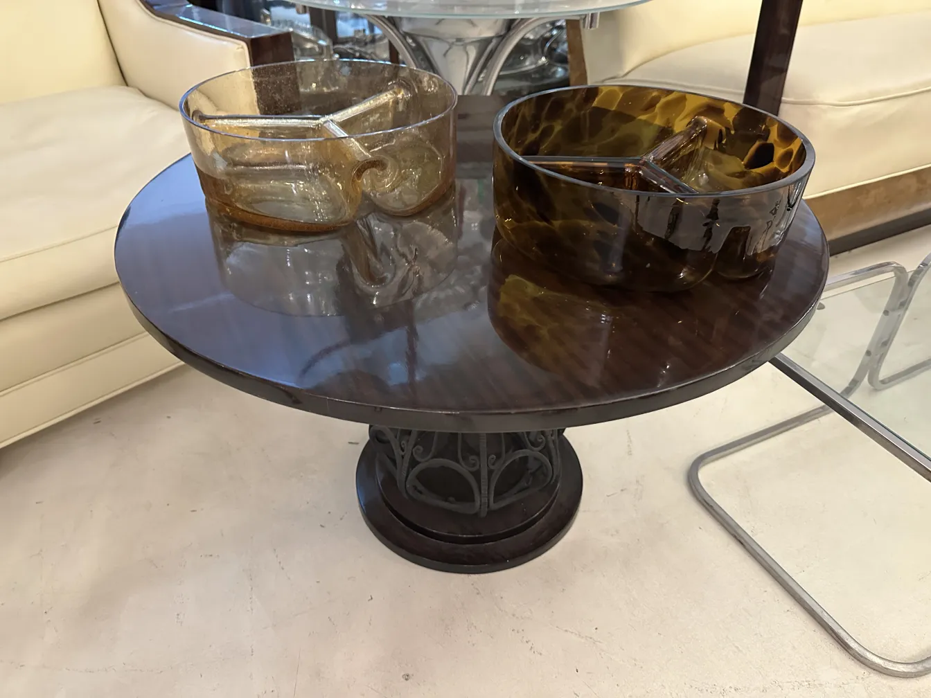 View of 2 antique small tables with simple design in a cozy setting.