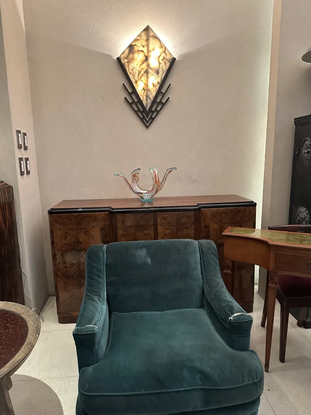 Antigua mesa ratona de estilo Charlotte Perriand en un ambiente elegante, decorada con un jarrón colorido.