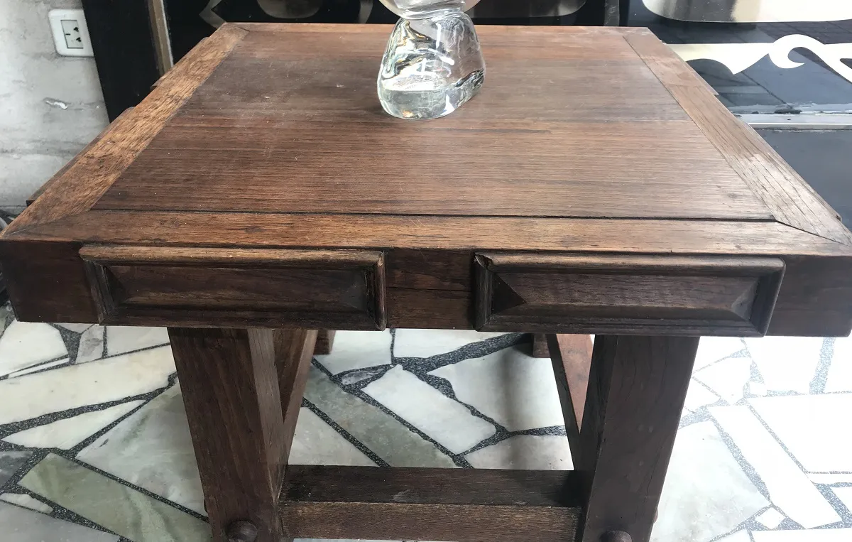 mesa de centro antiga com duas gavetas em um ambiente aconchegante