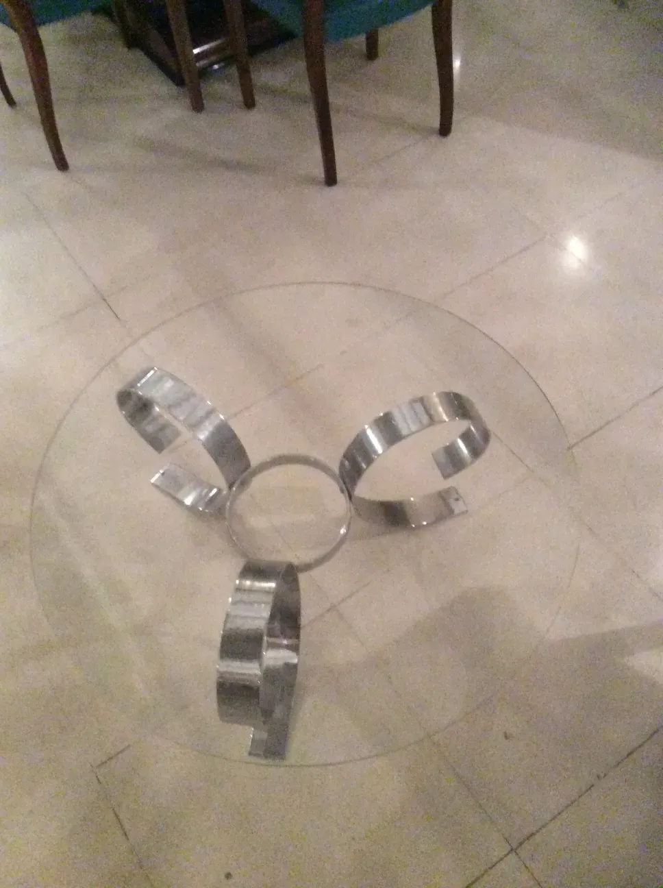 Antique coffee table with sculptural base. Silver color with a circular shape in the center.