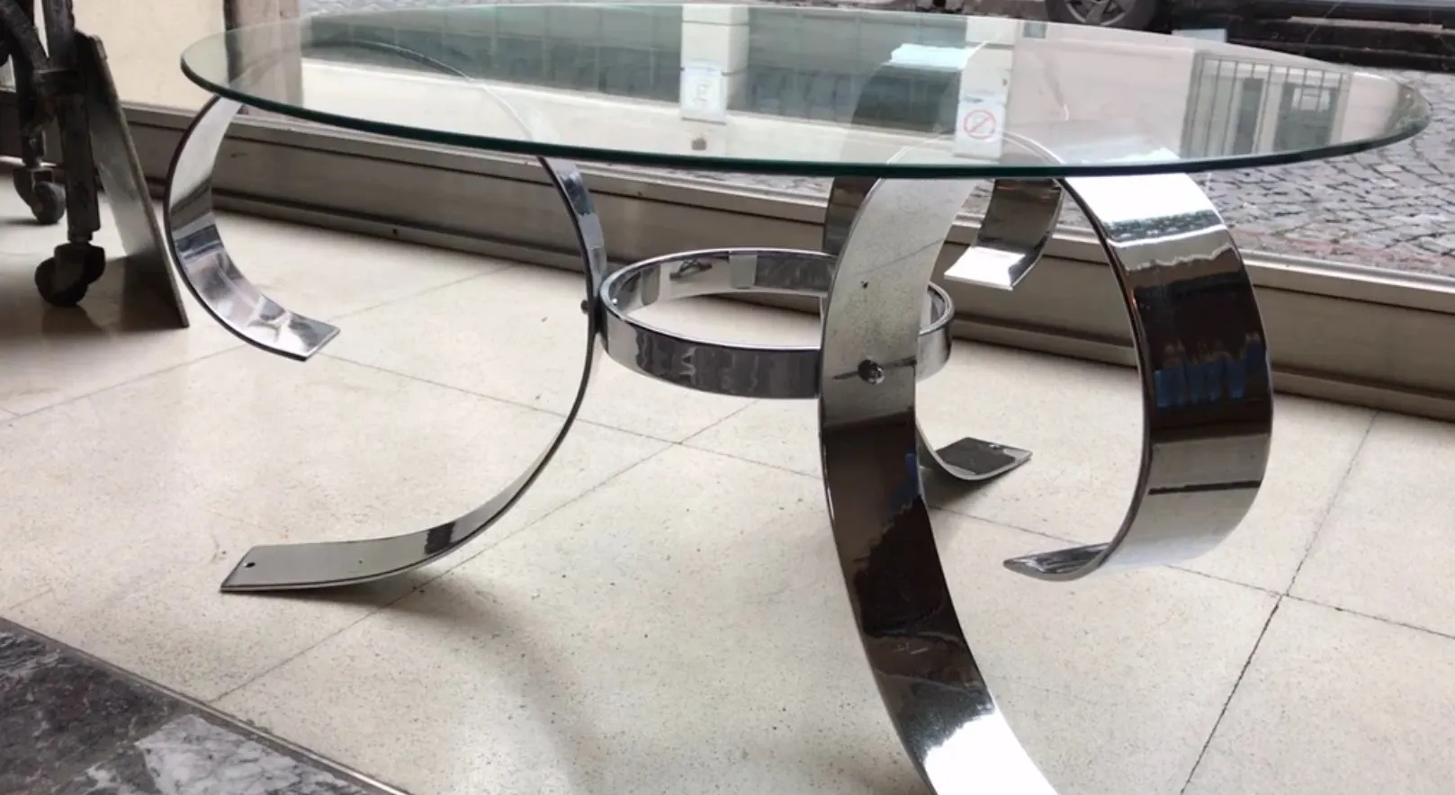 mesa ratona con base metálica curvada y tapa de vidrio