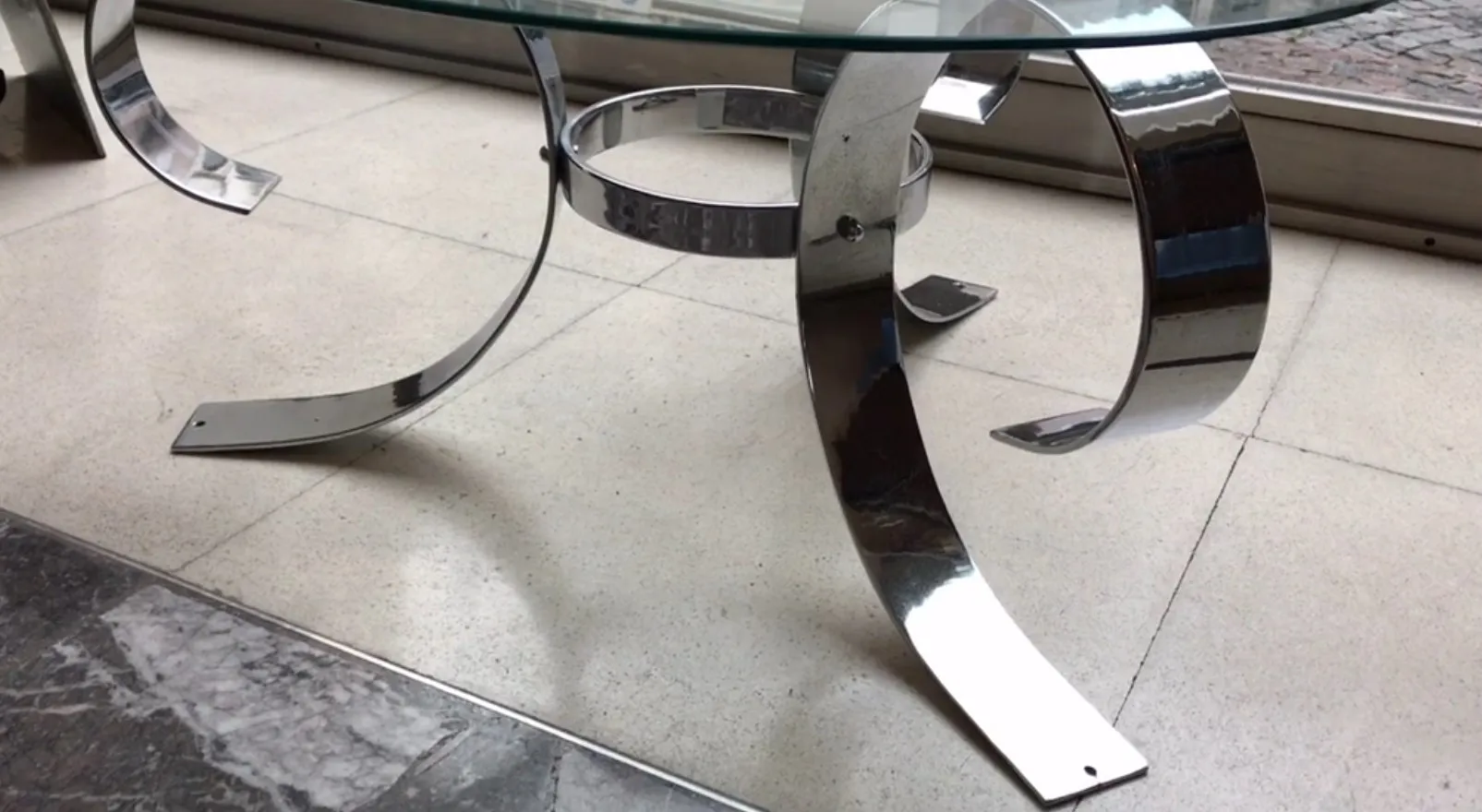 table basse ancienne avec base ronde sur un sol clair