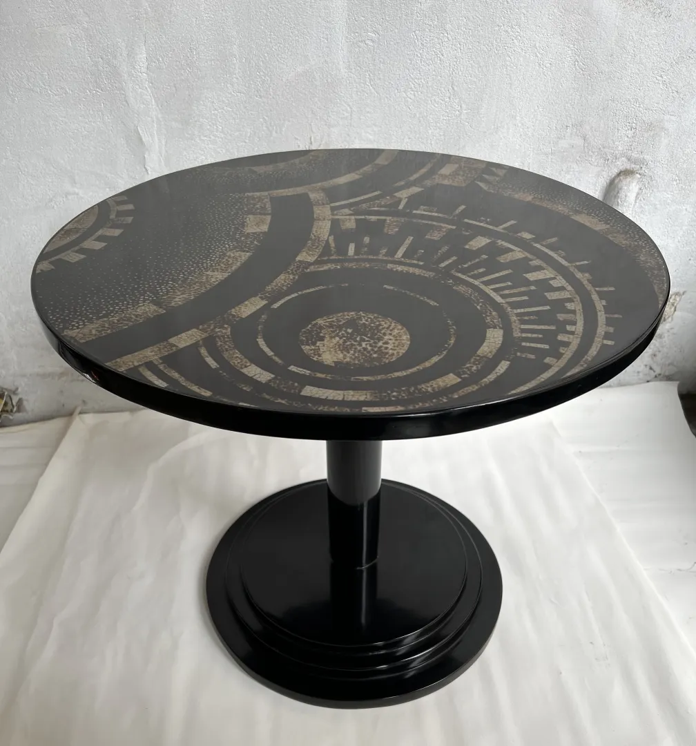 Mesinha decorativa antiga com tampo circular e base preta.