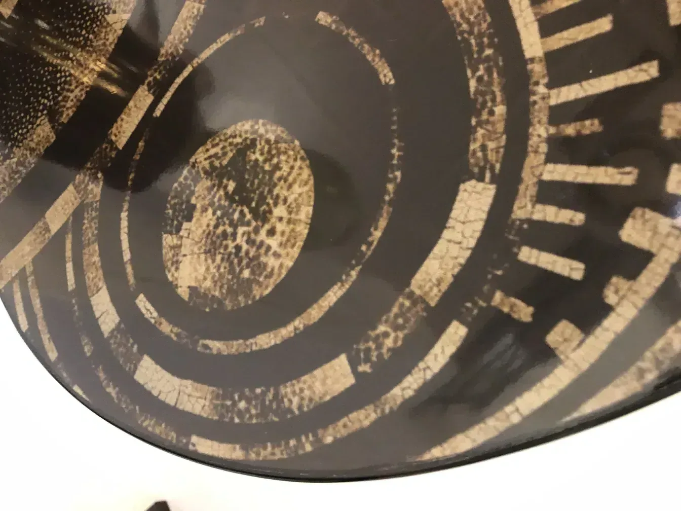 Antique small table featuring dark and light geometric patterns.