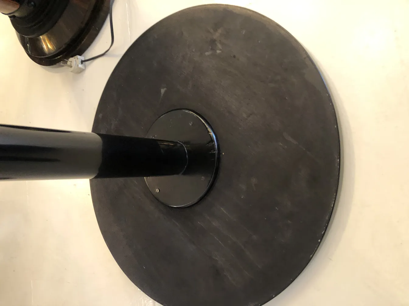 mesinha antiga redonda com base preta em fundo claro