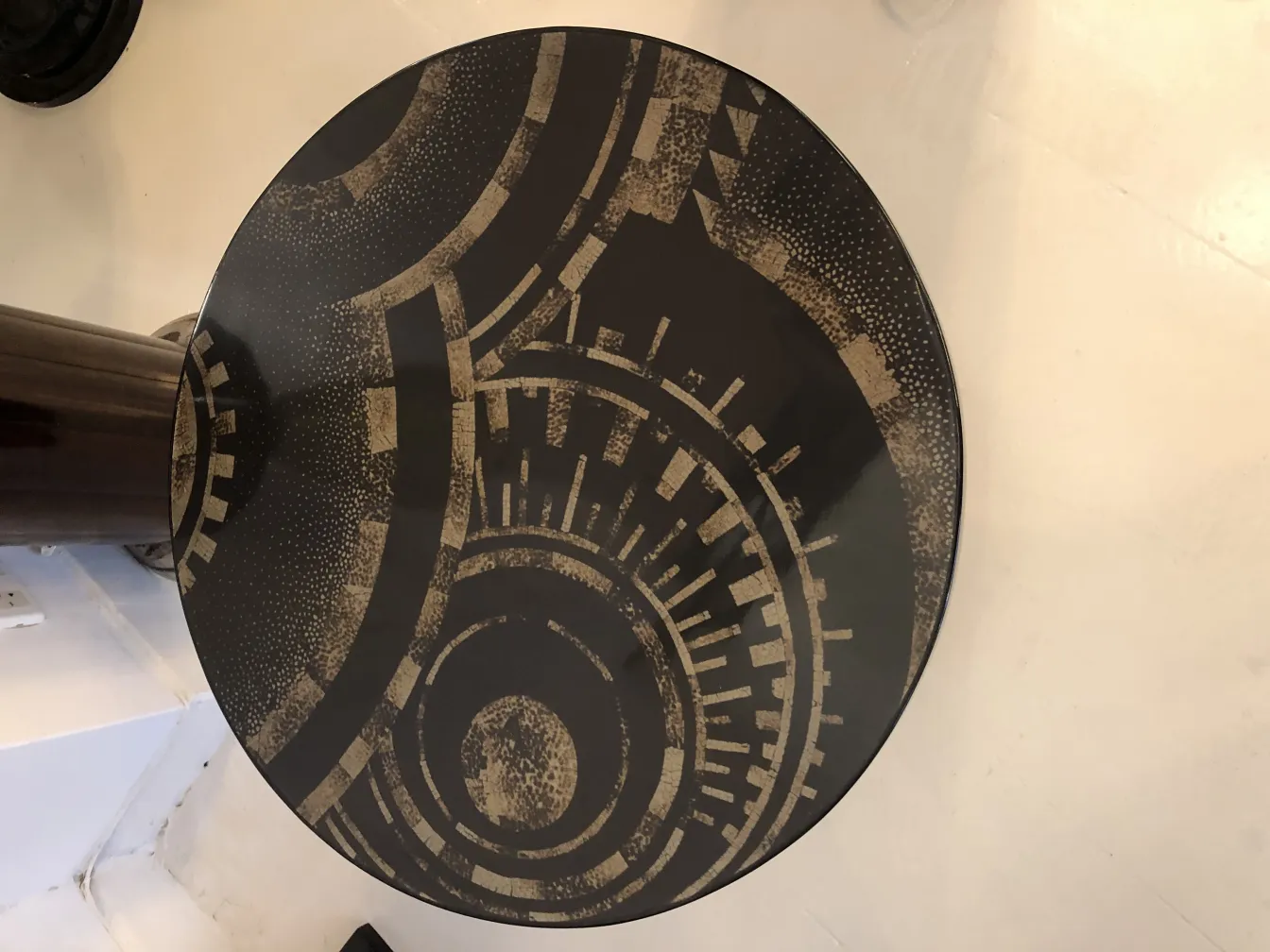 Mesita antigua con un diseño redondo y patrones geométricos en tonos oscuros