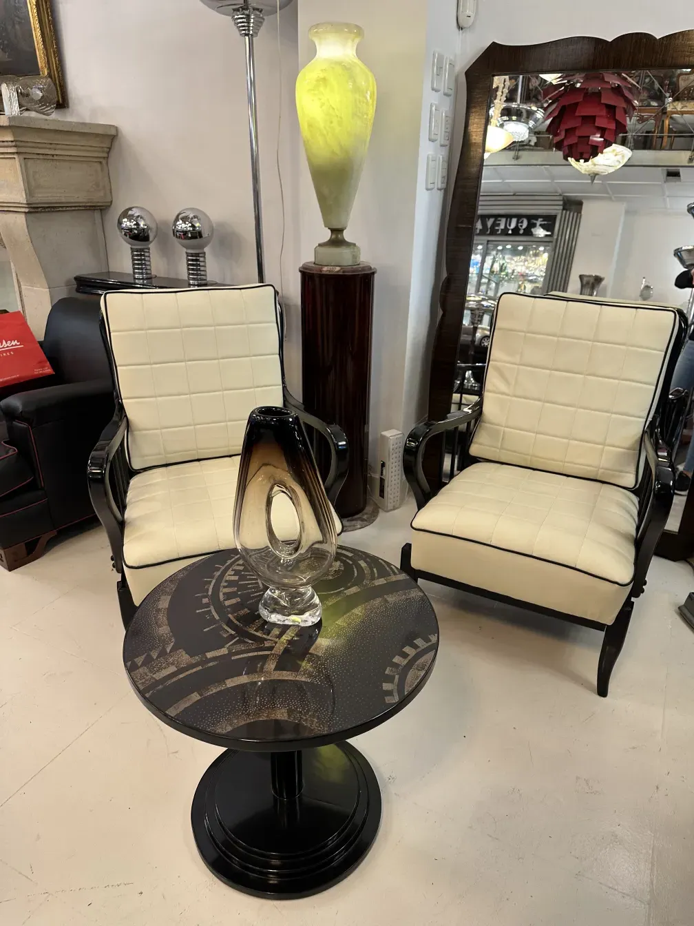 antiker kleiner Tisch mit rundem Design und eleganter Basis, verziert mit klaren visuellen Details, umgeben von Stühlen