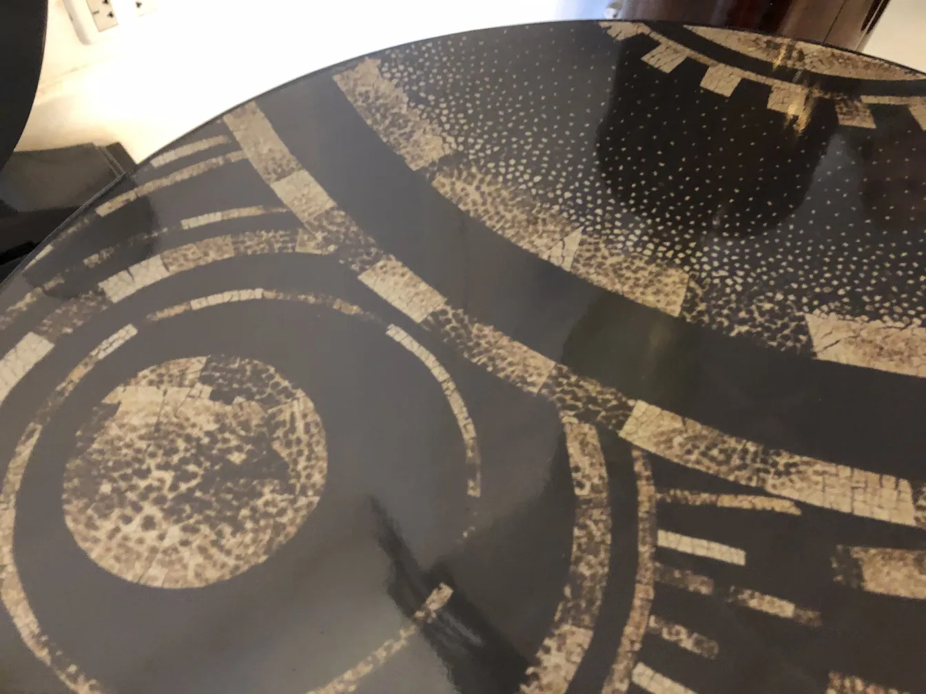 Antique small table featuring a geometric design on the surface.