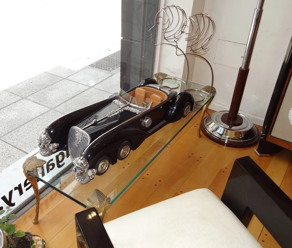 mesa de centro antiga no formato de um carro de luxo em um ambiente elegante