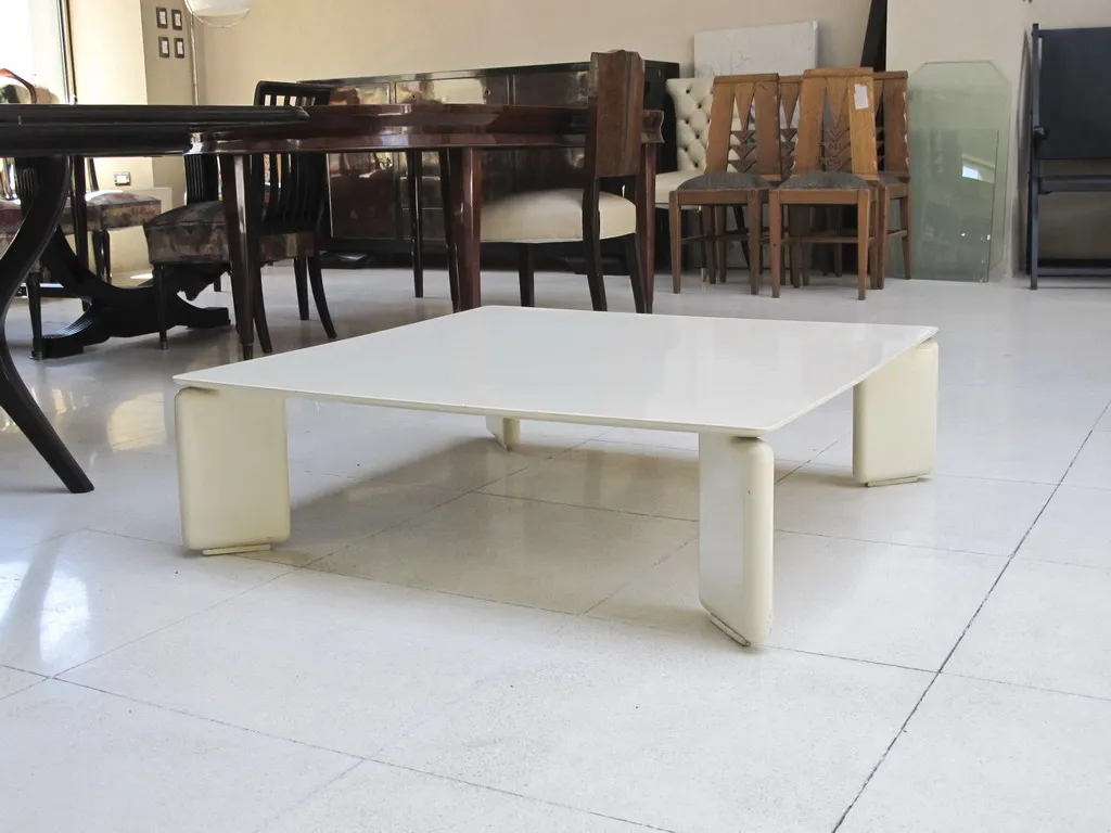 Mesa ratona antigua de líneas simples, ambiente con muebles variados.