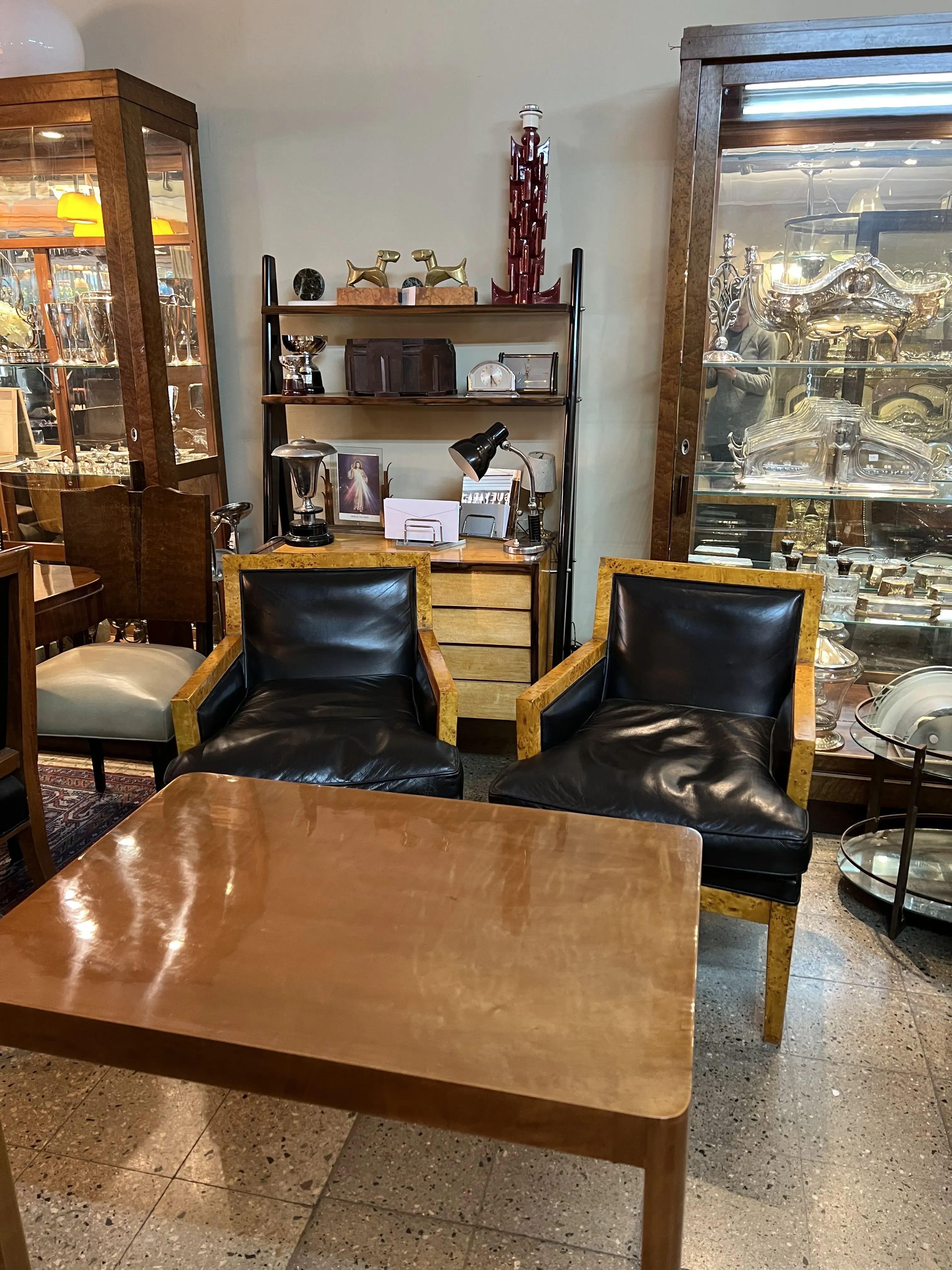 mesa de centro antiga em um ambiente aconchegante com cadeiras pretas