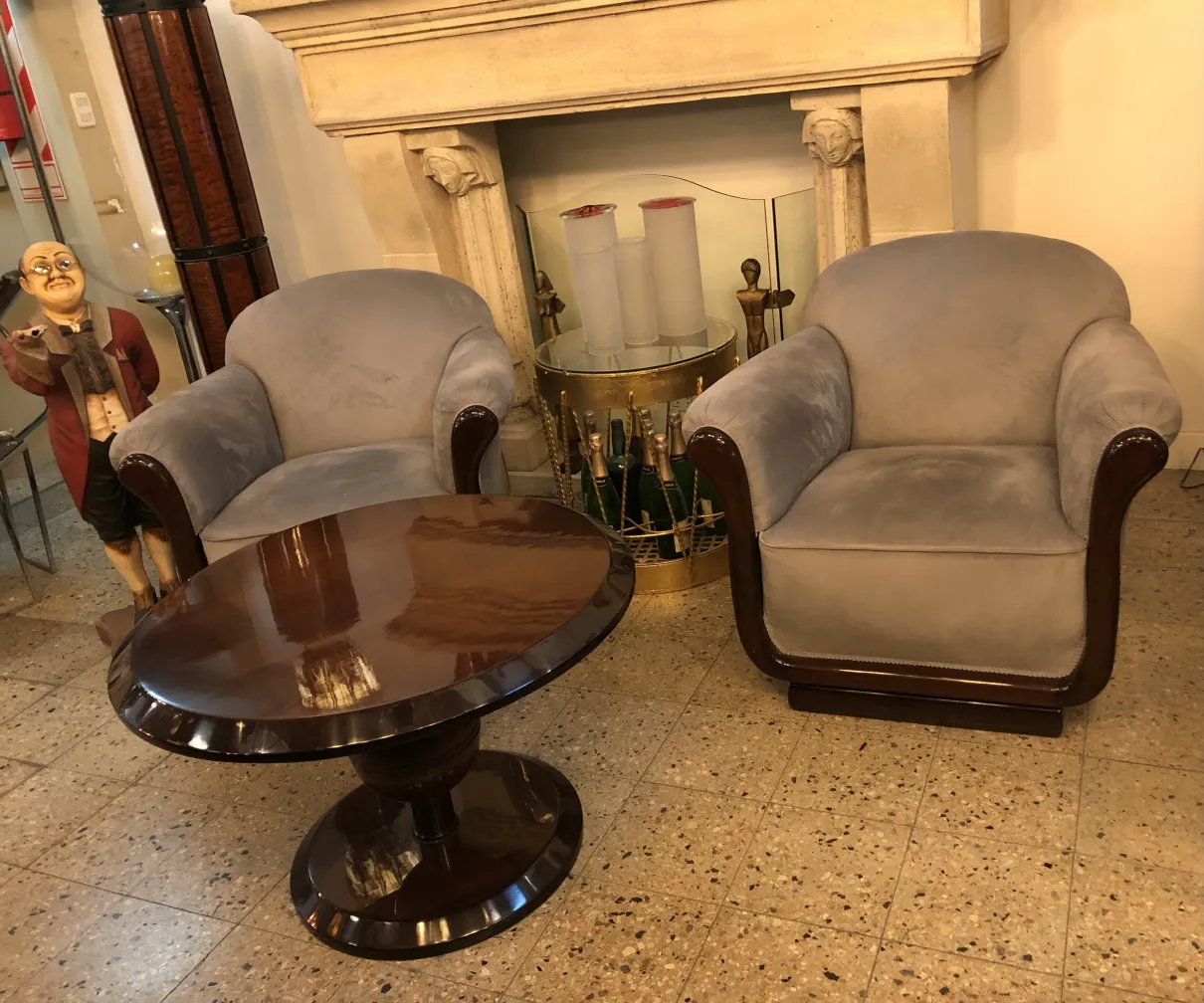 Tavolino da caffè antico ovale in un soggiorno accogliente con poltrone.