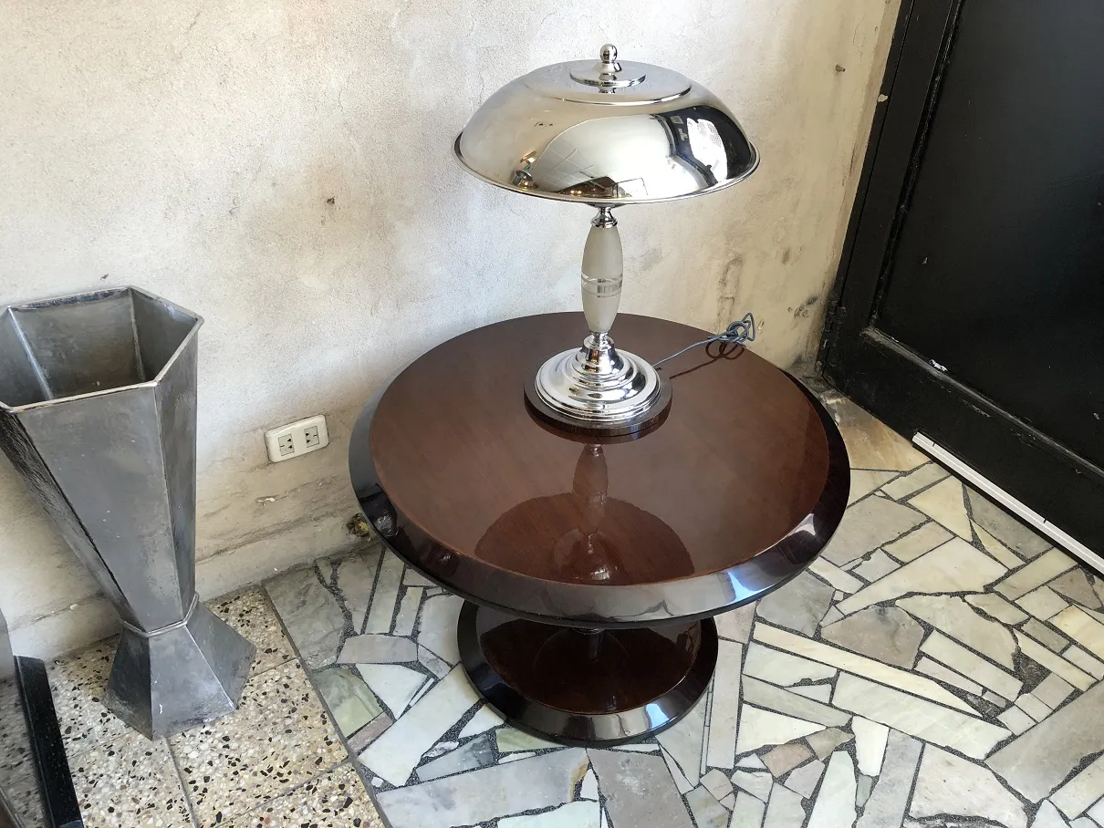 Antique coffee table with a lamp in a mosaic floor room.