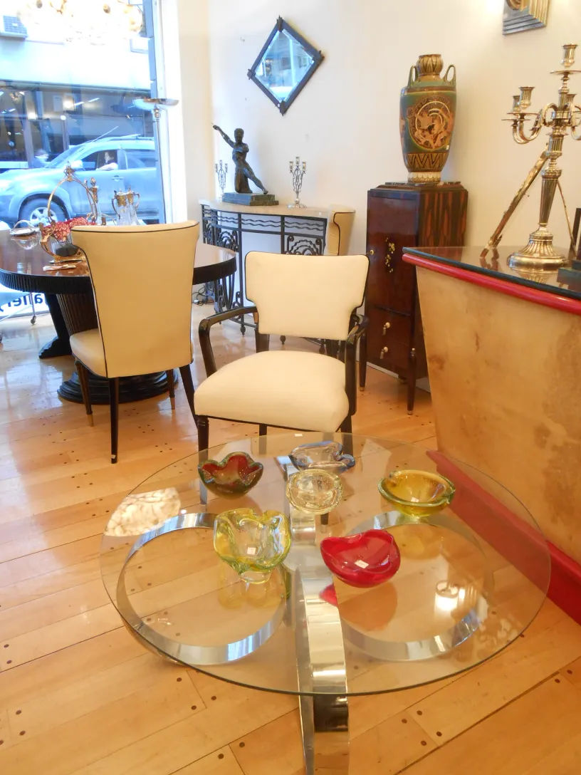 Mesa ratona antigua de vidrio con decoraciones art deco y platos coloridos