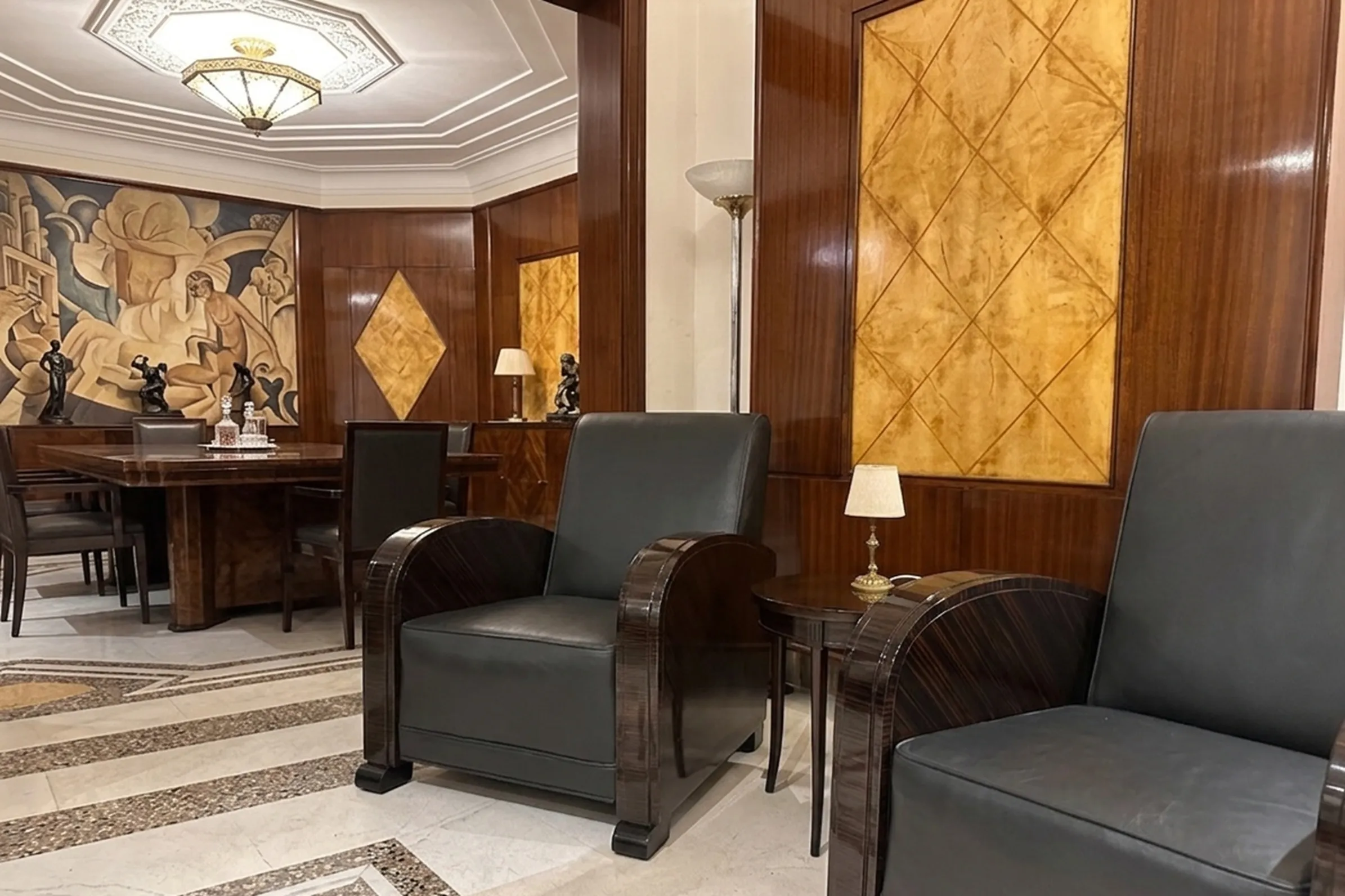 2 antique armchairs in an elegant living room with lamp.