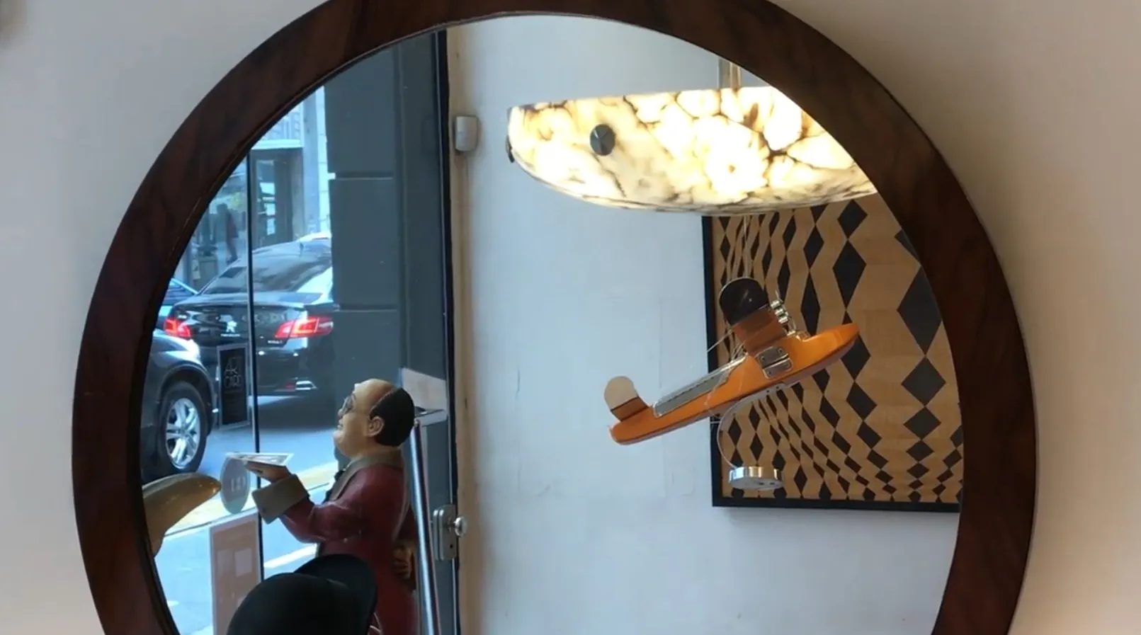 Dekorativer antiker Spiegel mit einer Figur im Hintergrund.