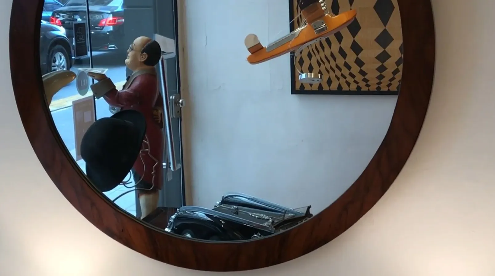 Miroir ancien rond avec des détails décoratifs, reflétant un environnement artistique.