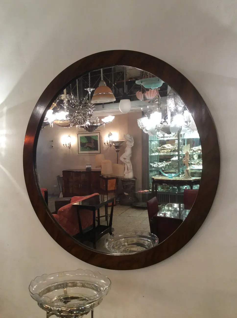 Antique decorative mirror in round shape displayed in elegant setting.