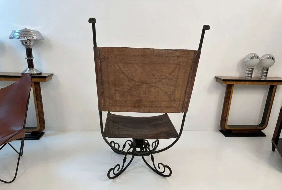 Fauteuil antique de style art déco, avec des courbes élégantes dans un cadre minimaliste.